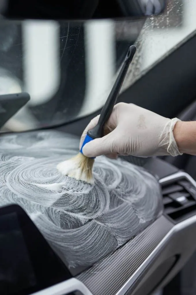 Detailer cleaning the interior console of a car