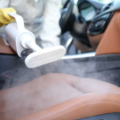 Car seat being steam cleaned