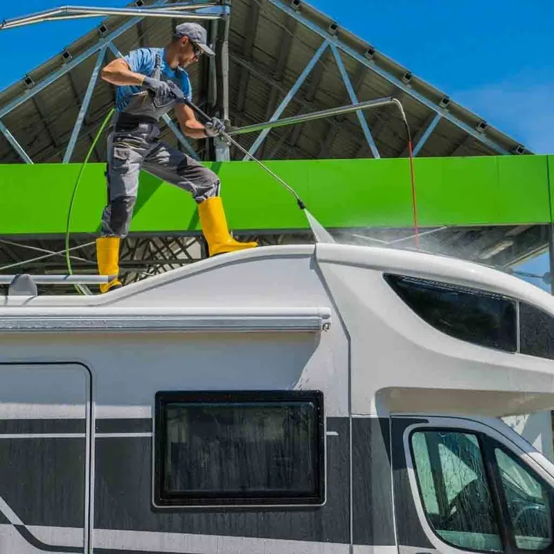 Detailer washing the side of a large RV